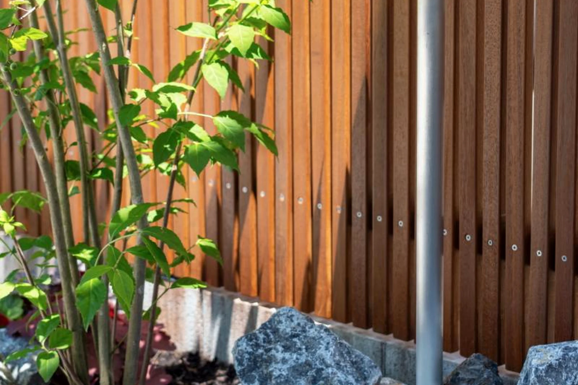 植栽と石材に調和するウリンフェンスの細部