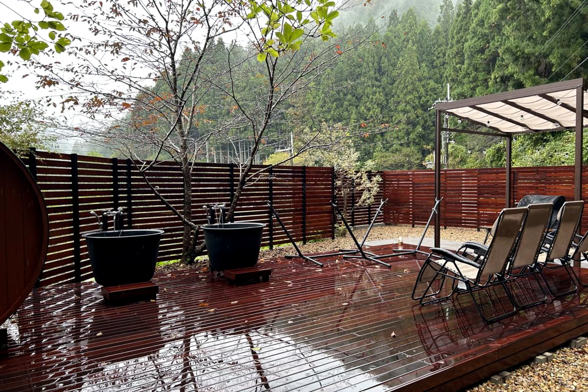 雨に濡れたウリンデッキとパーゴラまわりの外構空間