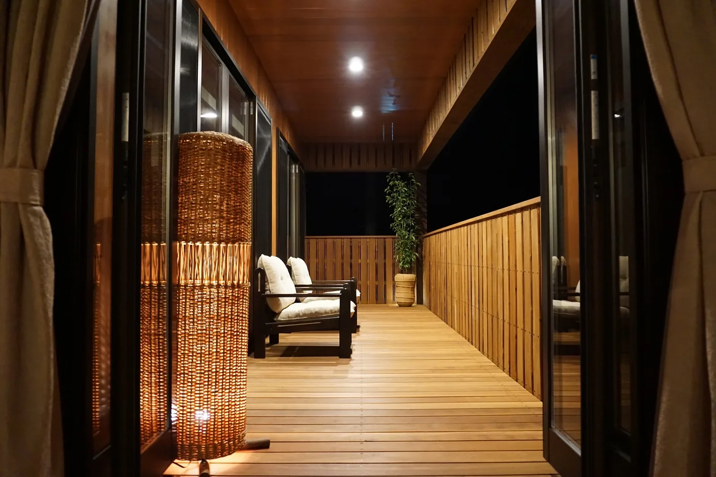 室内からつながる夜の屋根付きウリンバルコニー全景