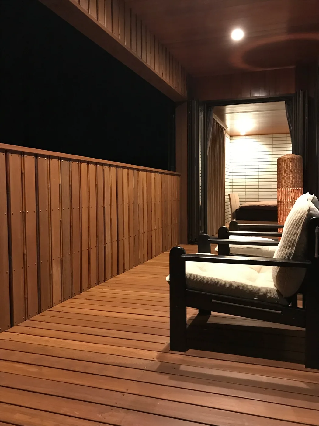 夜のバルコニーで椅子とウリンフェンスが見える写真