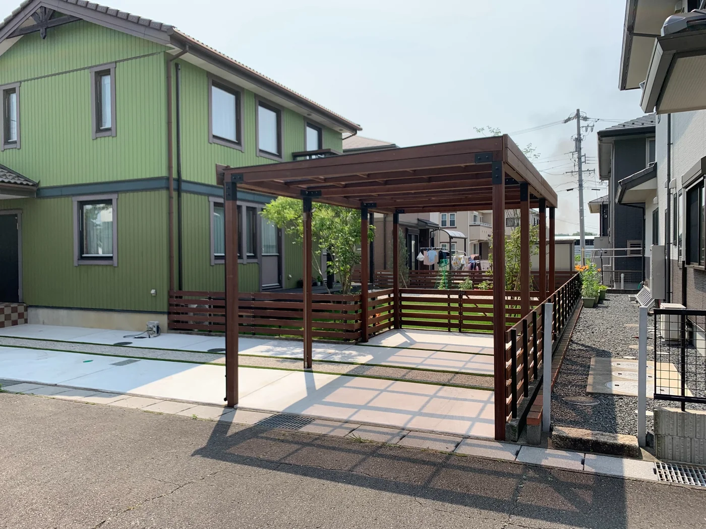道路側から見たウリンパーゴラと低いフェンスの全景。