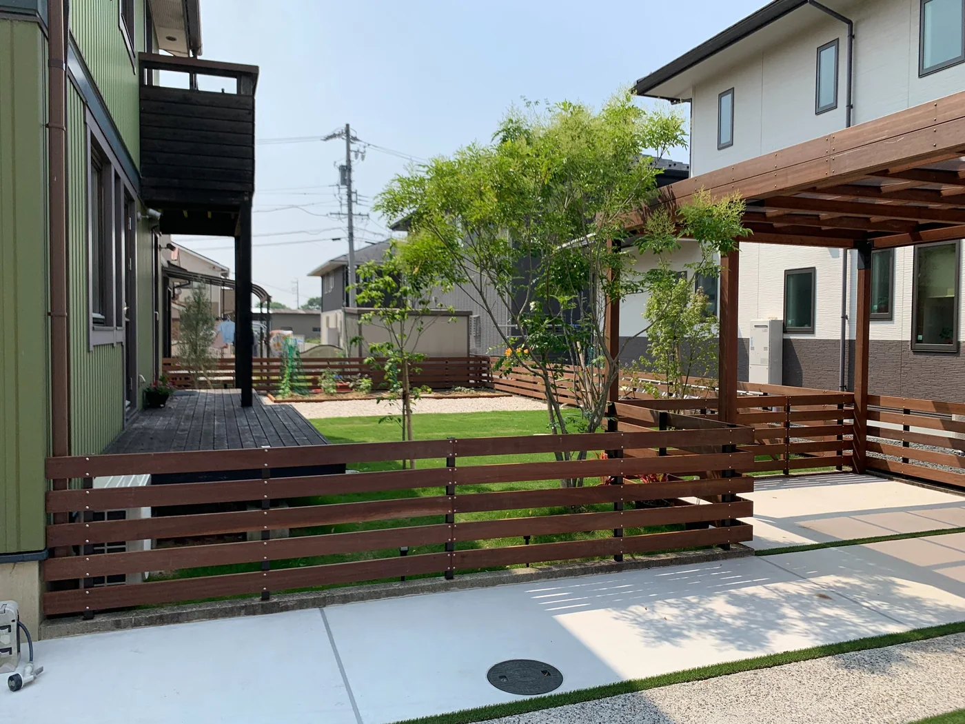低めの横板フェンスで庭をゆるやかに囲う構成。