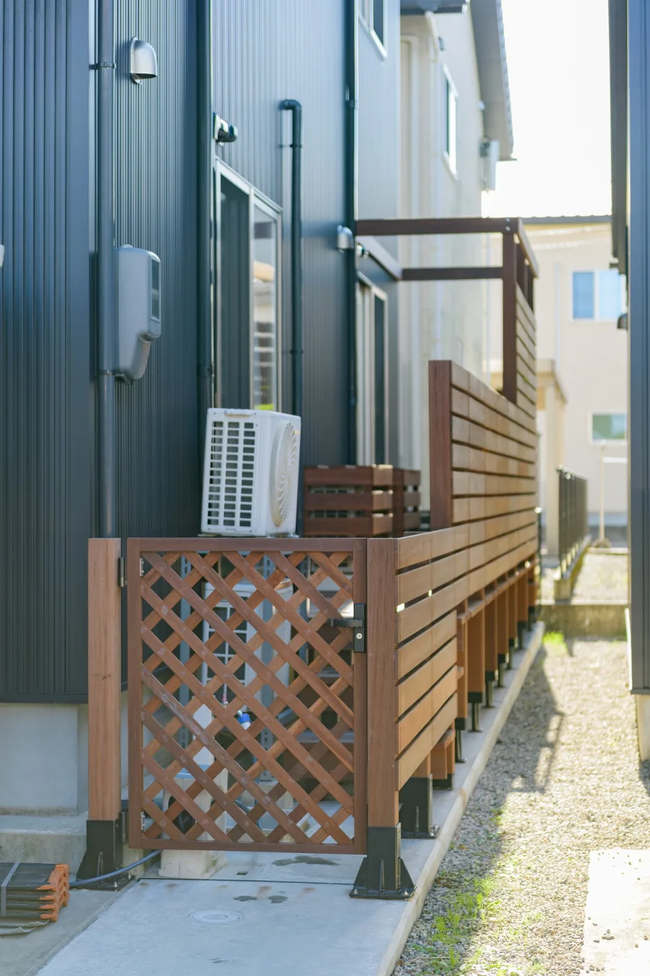 室外機まわりに設けたウリンの格子扉と横板フェンス