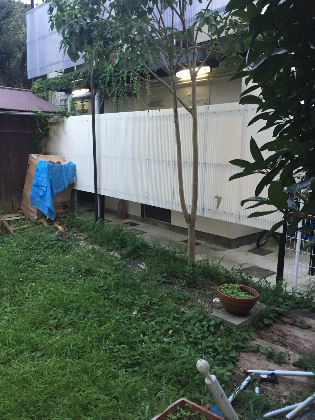 照明、水鉢、植栽を取り込んだ屋根付きウリンデッキを庭や建物とともに見る全景