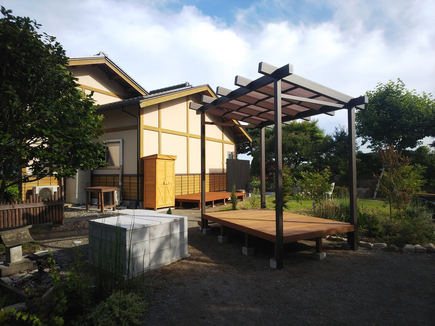 和風住宅の庭へ設けたウリンデッキ、パーゴラ、縦格子スクリーンを庭や建物とともに見る全景