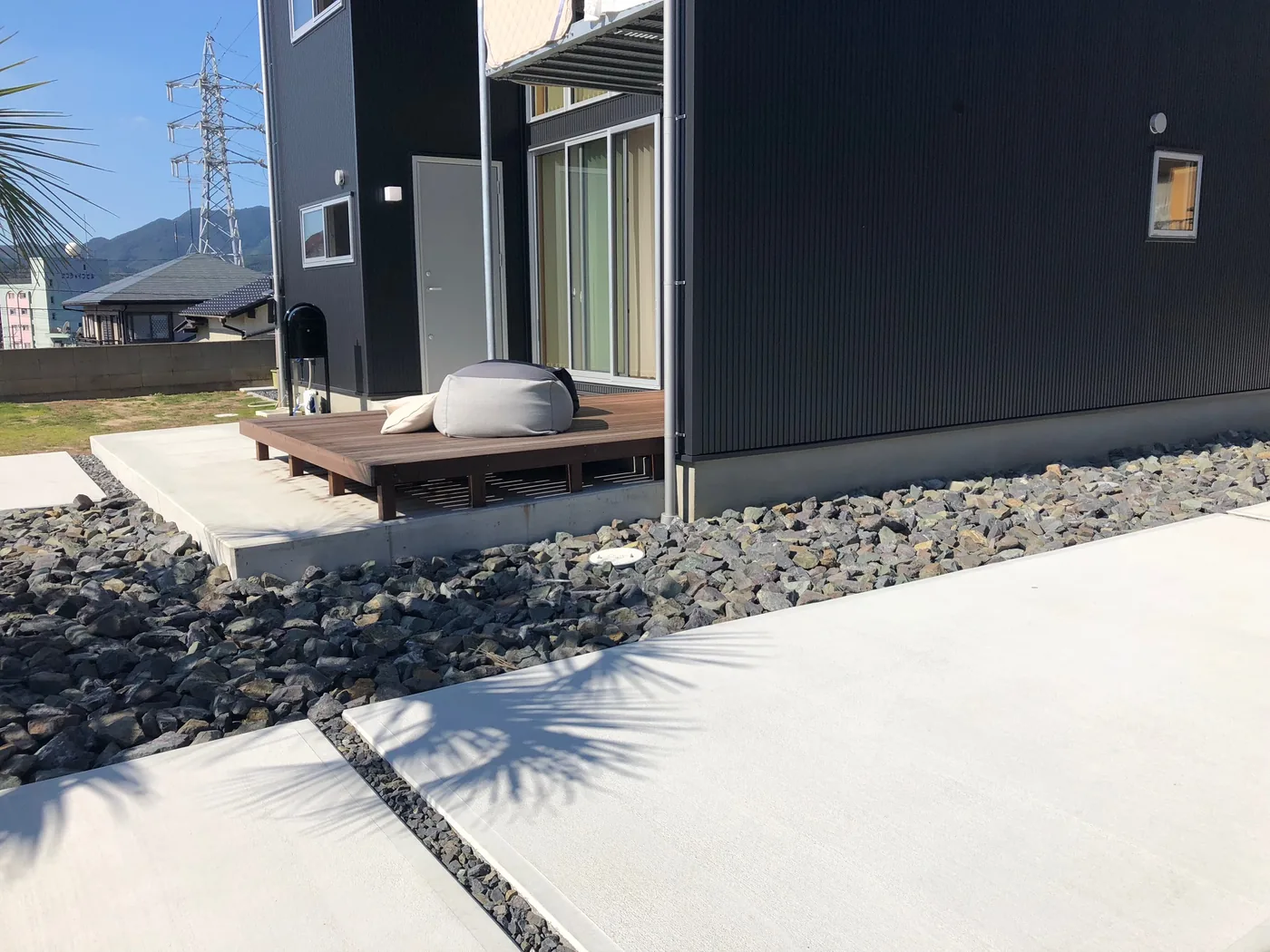 黒い外壁の掃き出し窓前に設けたウリンミニデッキ
