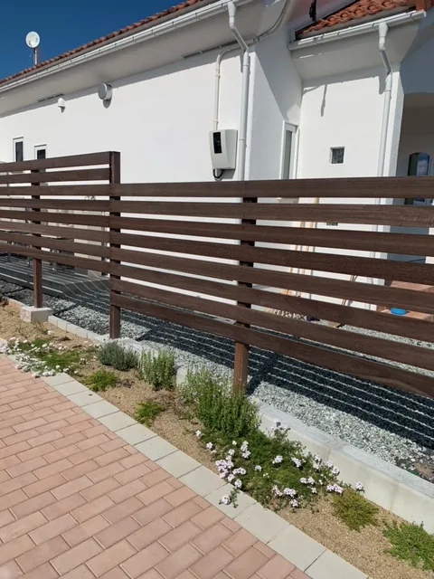 花壇の植栽越しに見る高さを抑えた横板フェンス