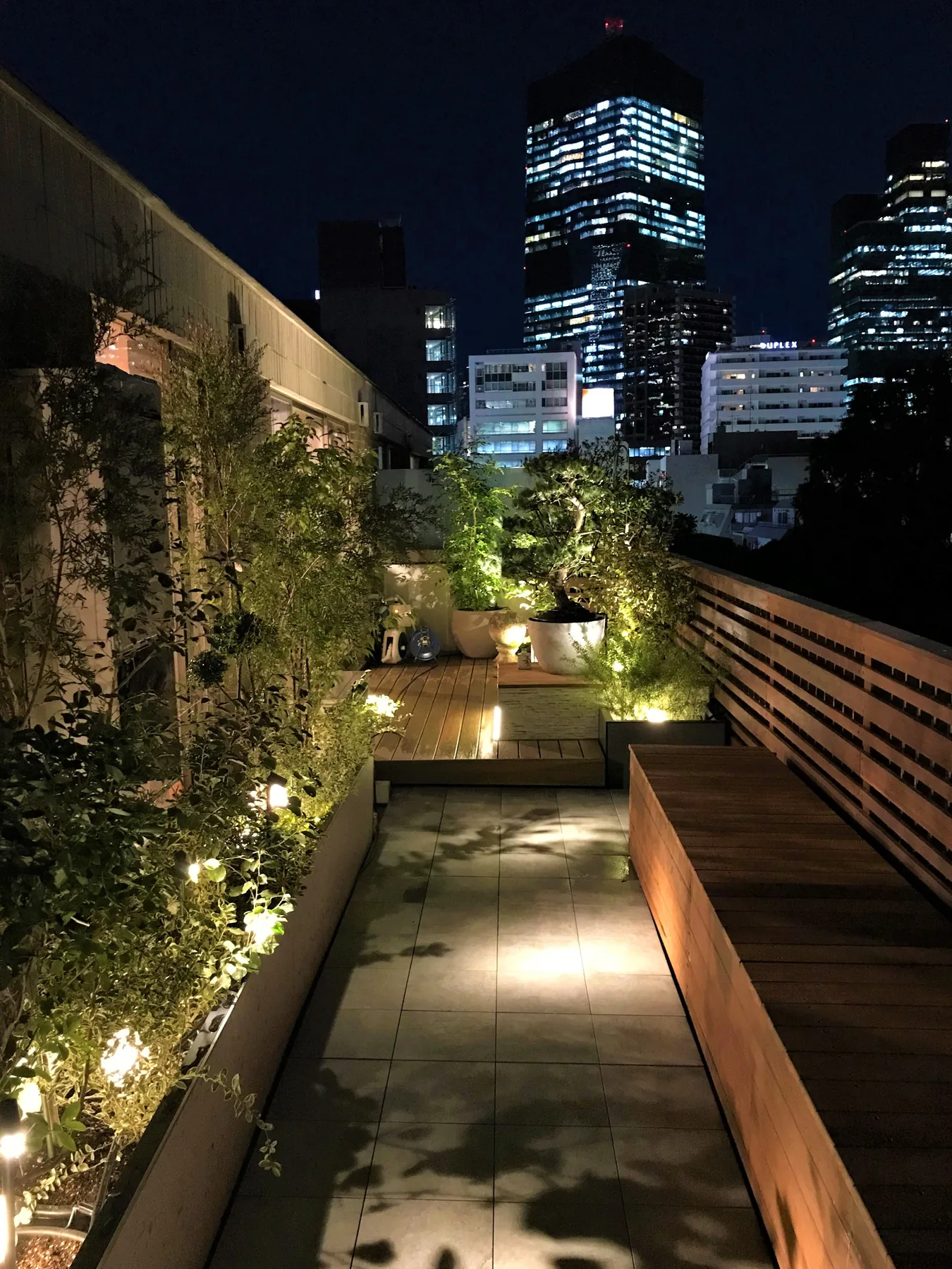 都市夜景を正面に望むウリンフェンスとロングベンチのテラス