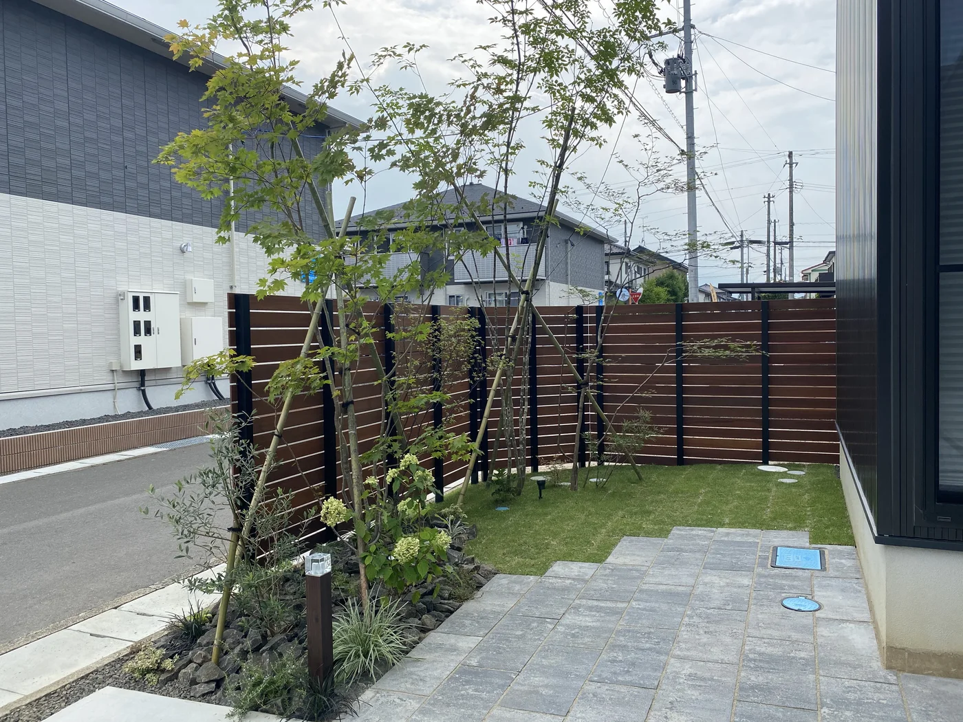 芝庭の内側から見る角部の横板フェンスと植栽