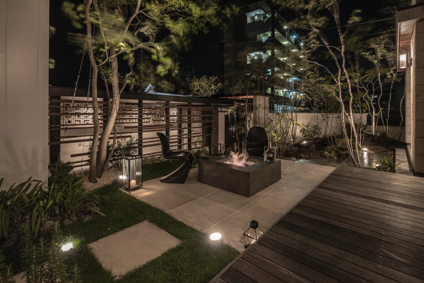 植栽と石材、木の通路を組み合わせた夜の庭