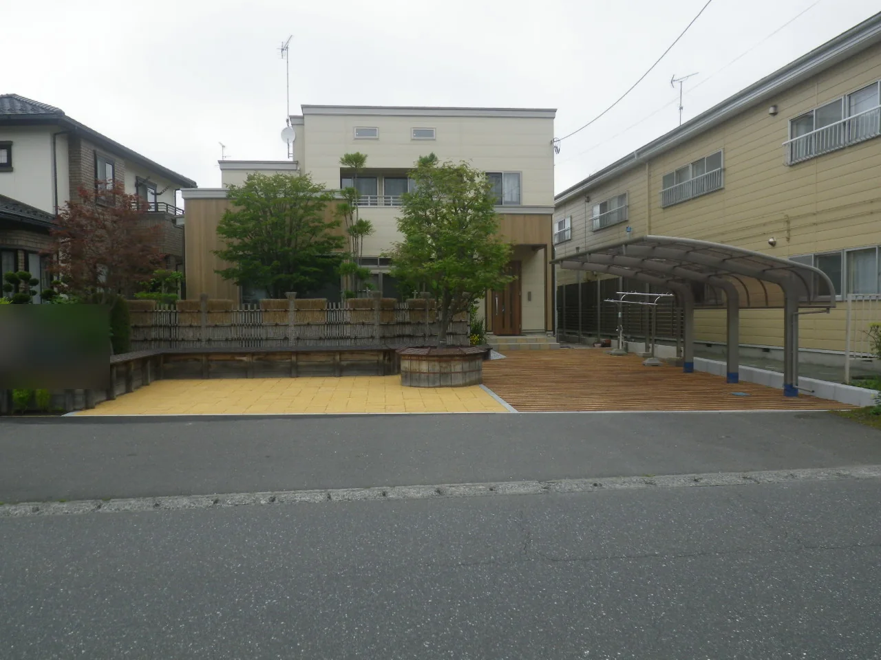 建物前の広場と屋根付きウリンデッキを見渡す外観