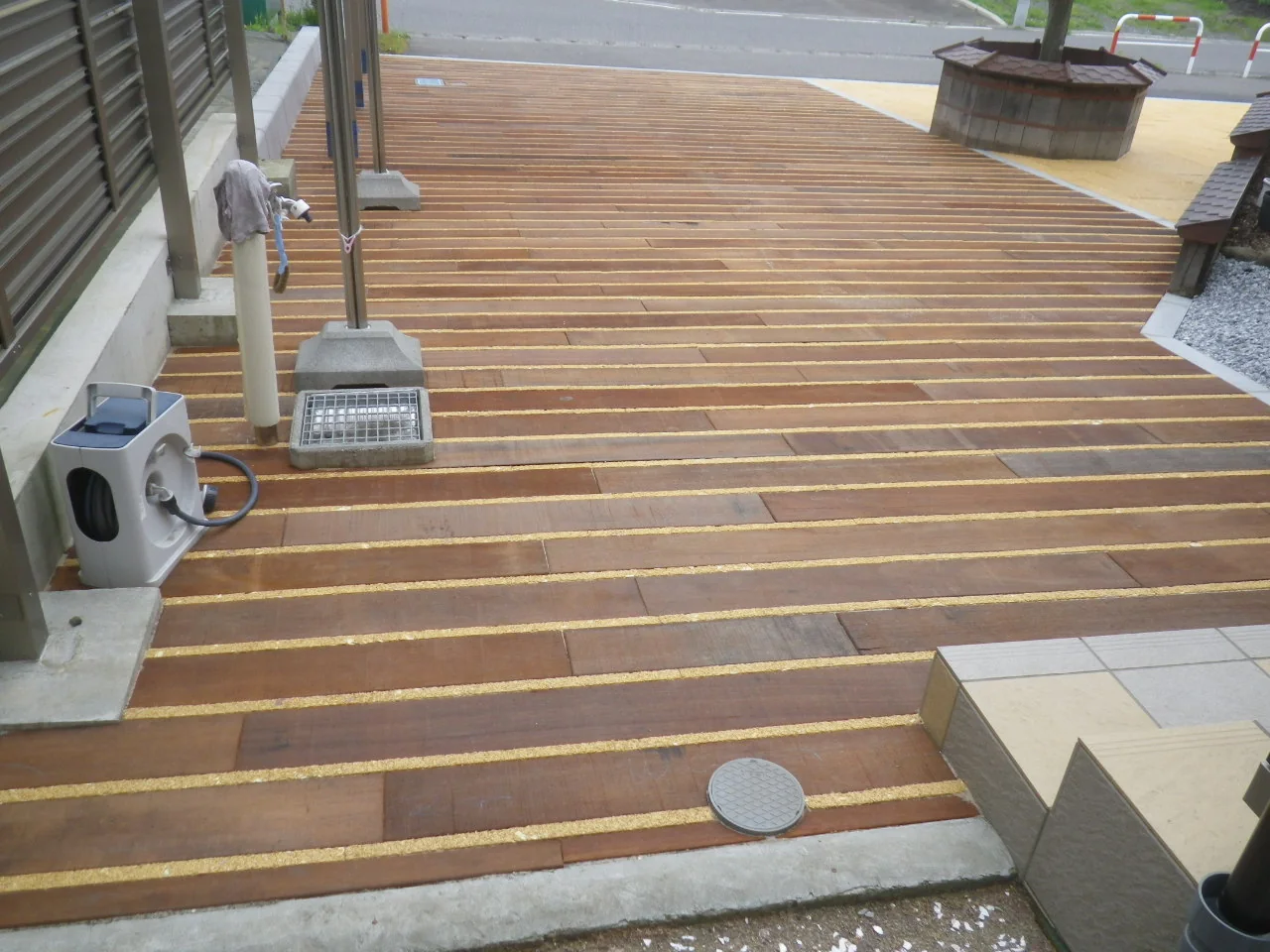 建物沿いに連続する木床と既存設備の納まり