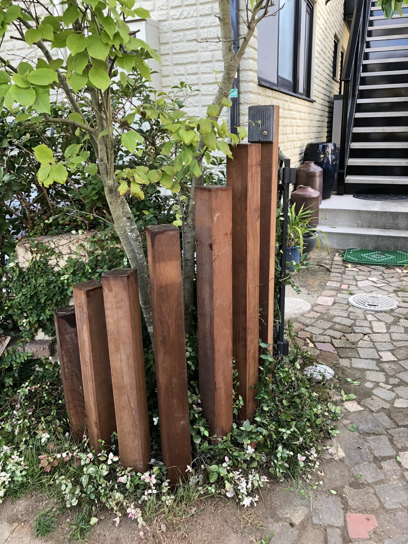 既存植栽の間に並べた高さの異なるウリン縦材