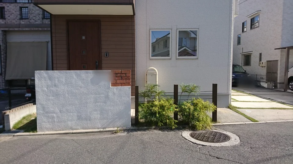 道路側から見る玄関植栽と木製ポール