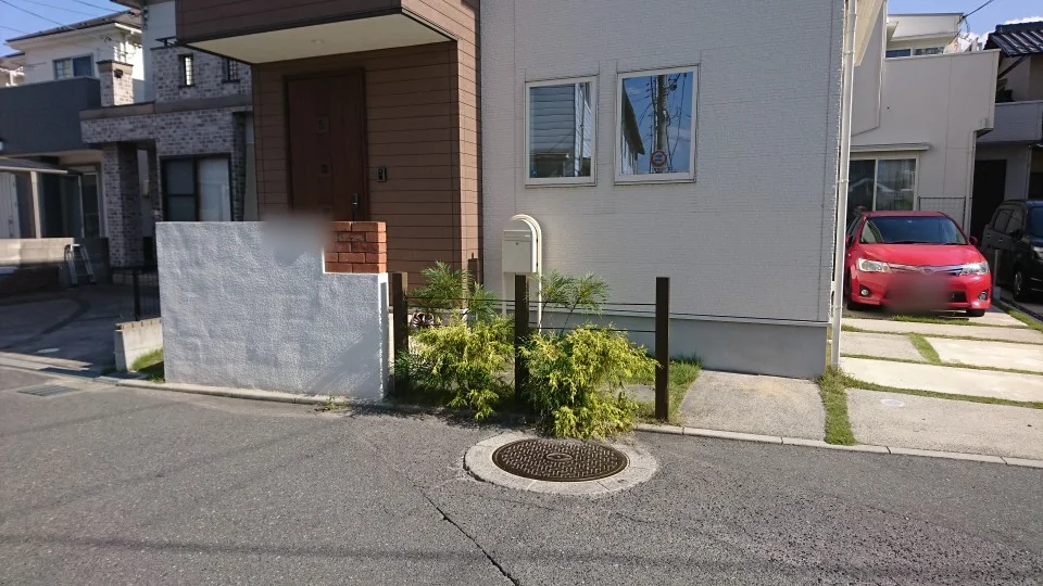 白い門塀と植栽に添えたウリン角柱