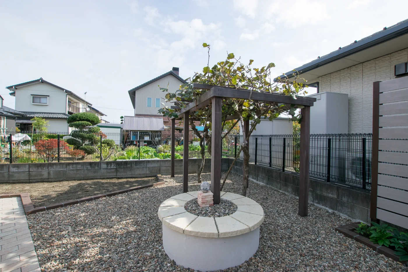 円形花壇を囲うウリン柱と果樹棚の全景