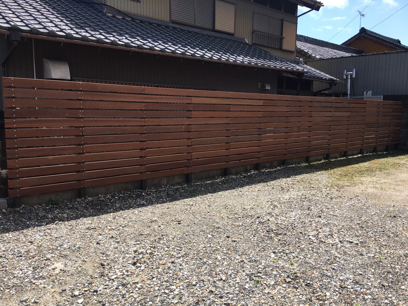 砂利の境界に沿って長く続くウリンフェンス全景