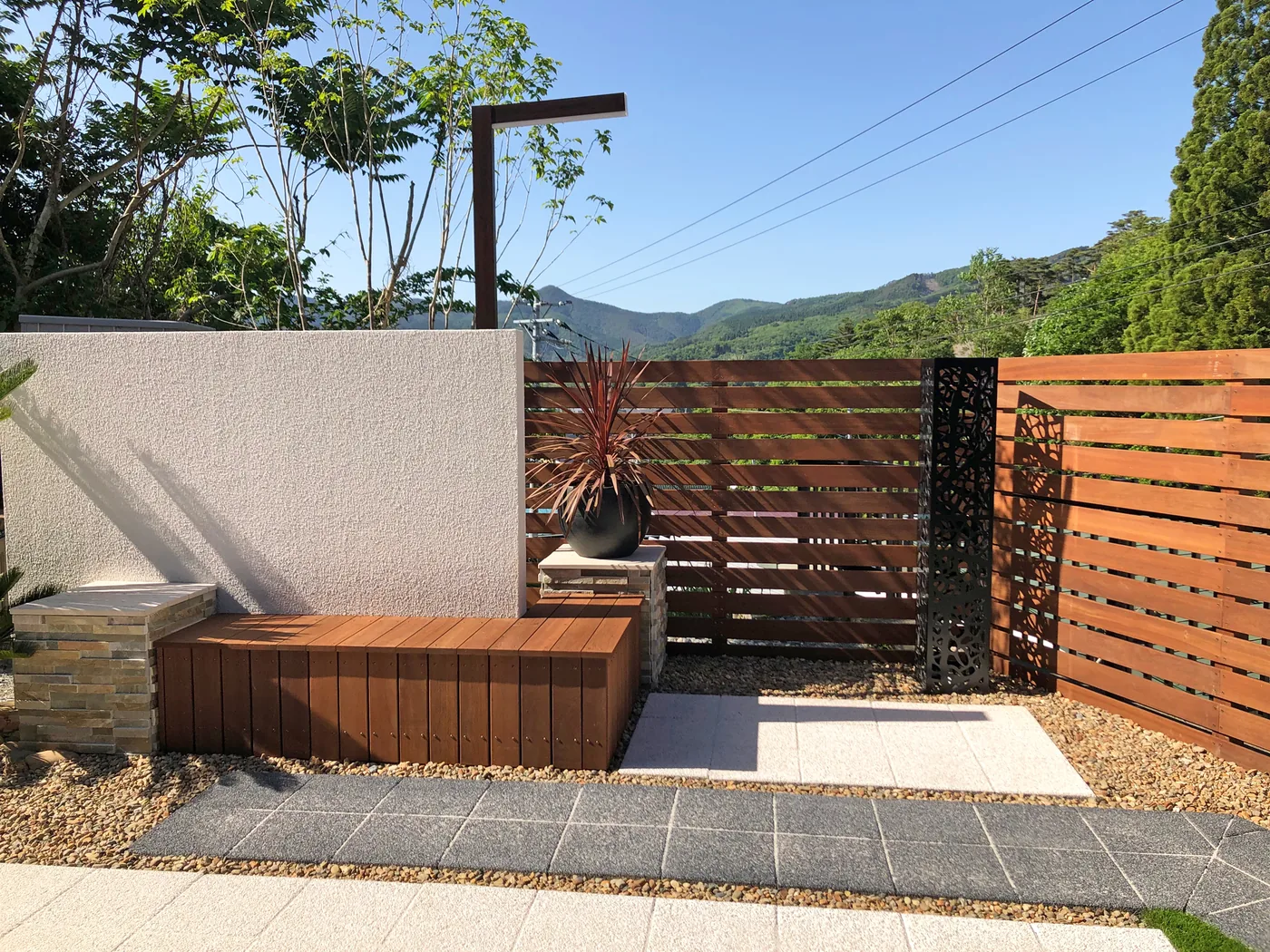 山並みを背景にしたウリン横板フェンスと造作ベンチ