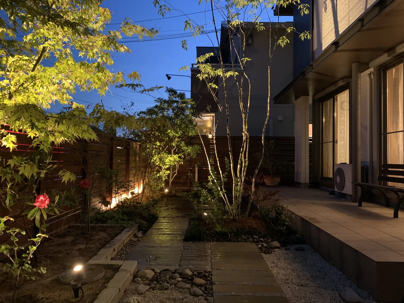 植栽の光とウリン横板フェンスが重なる夜の庭