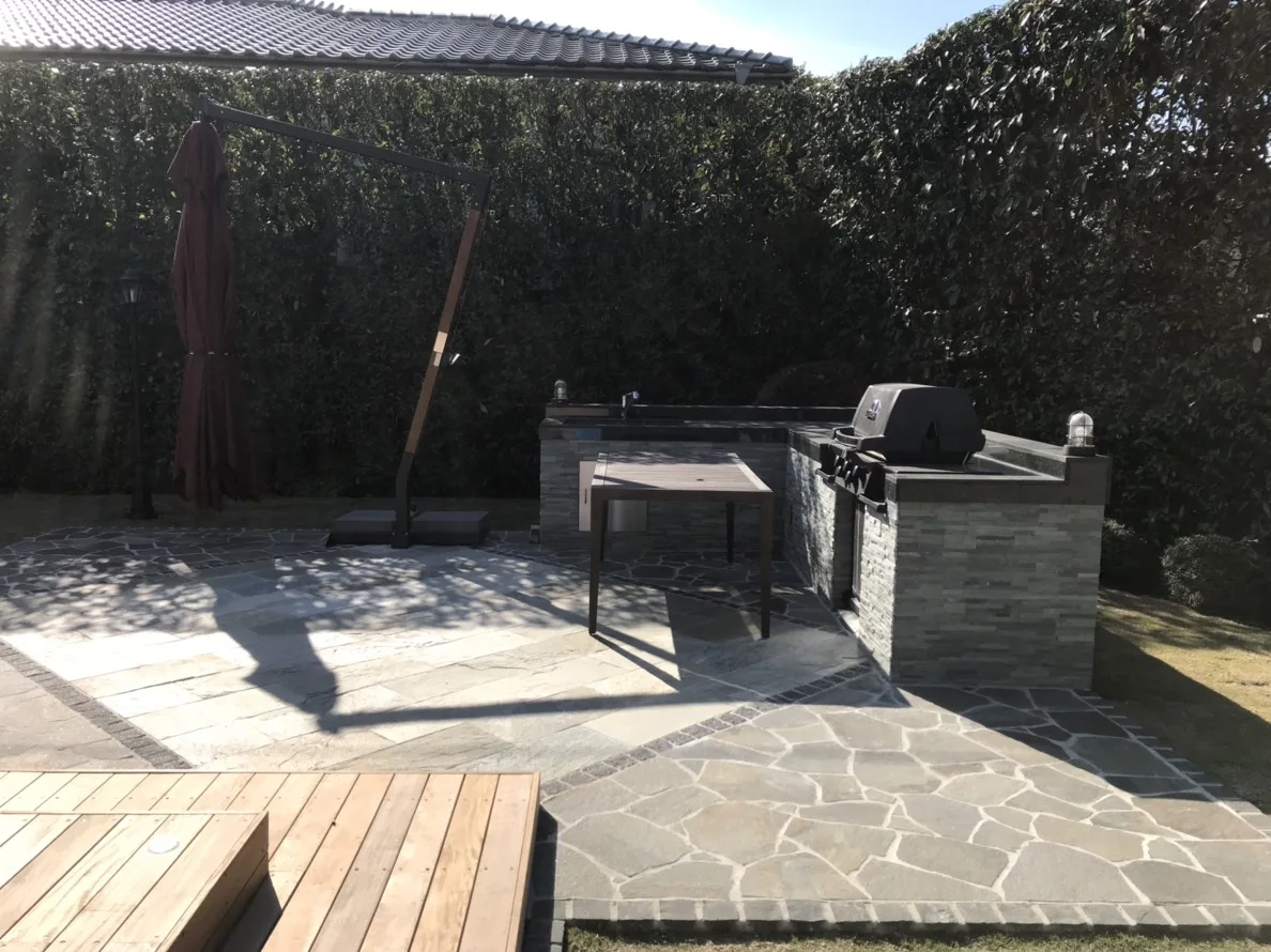 石貼りの屋外キッチンと木床の取り合い