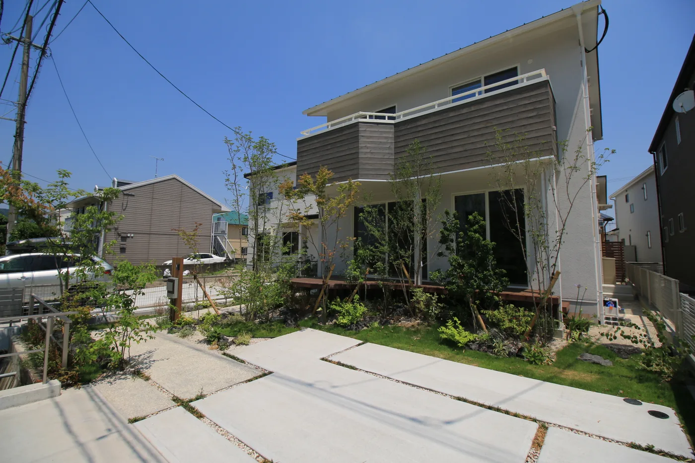 駐車場側から見る住宅と植栽、縁側デッキの全景
