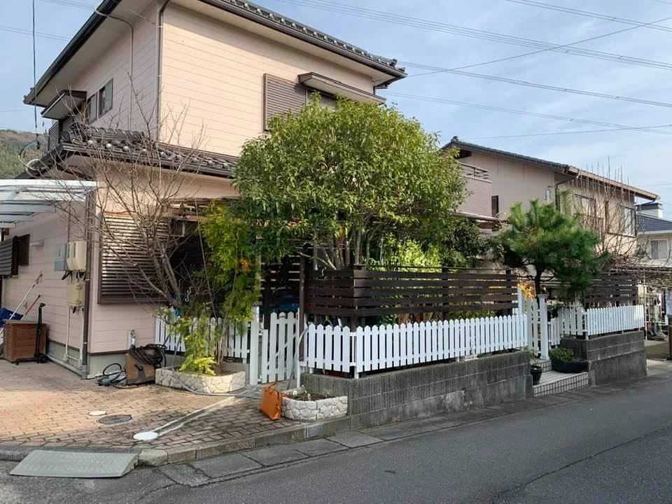 道路側から見る植栽に囲まれた住宅外観
