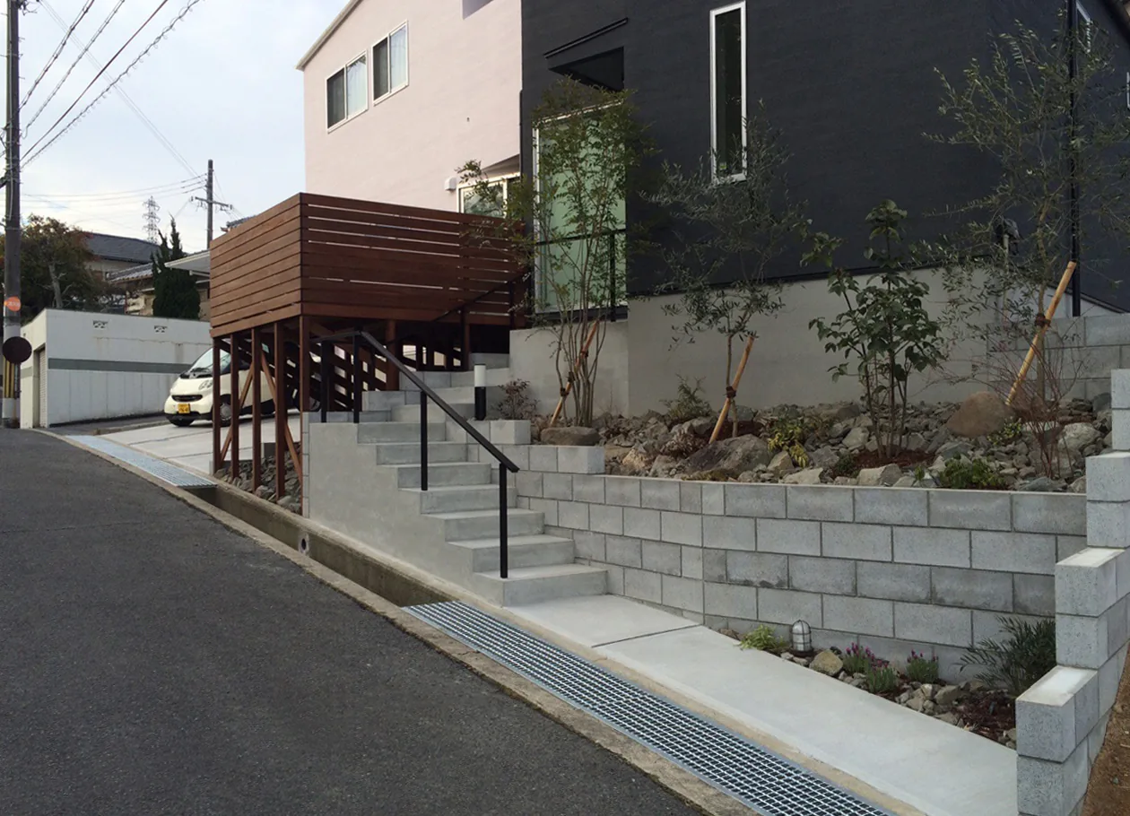 階段と擁壁を含めて確認できる高床デッキの道路側全景