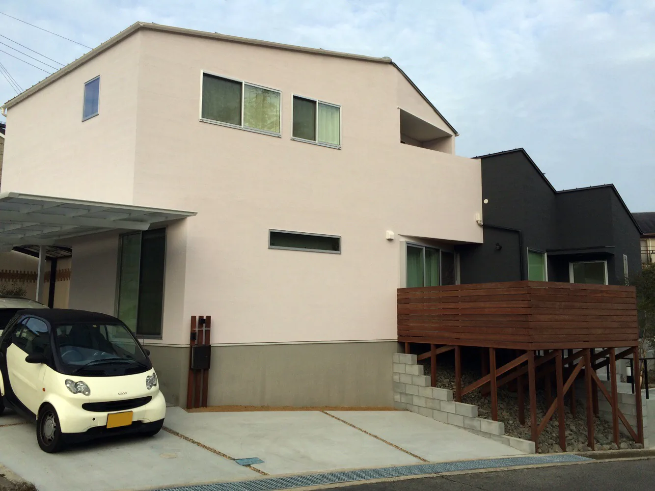 白と黒の住宅外観に張り出すウリン高床デッキ