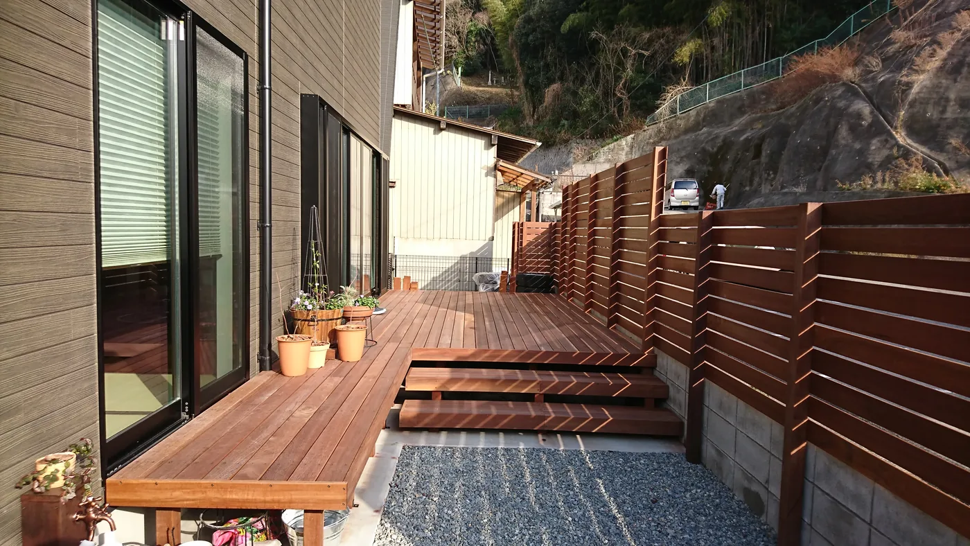 細長いデッキと段差ステップ、横板フェンスの庭側全景