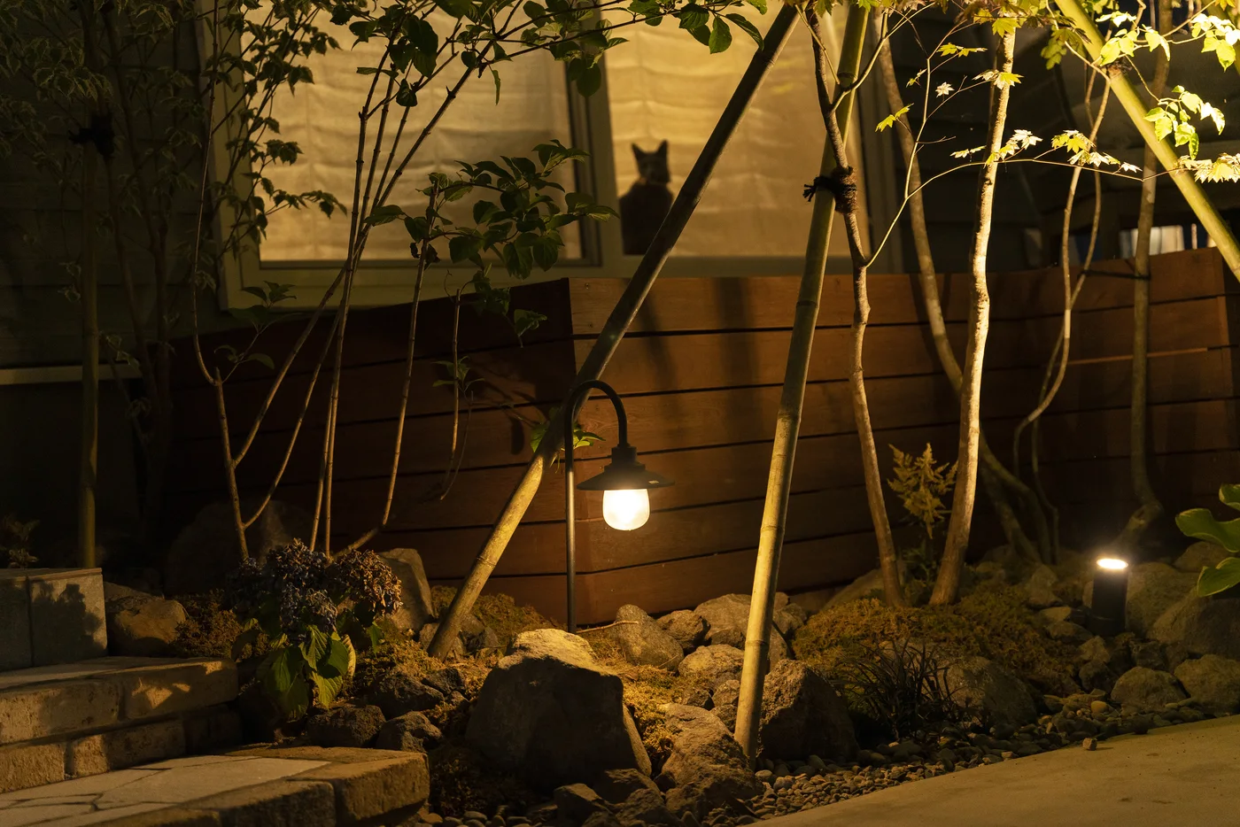 足元灯が石と植栽を照らす前庭の夜景