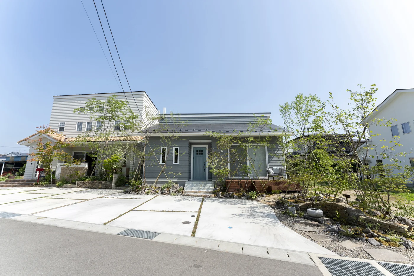 道路側から見渡す石畳と植栽の前庭全景
