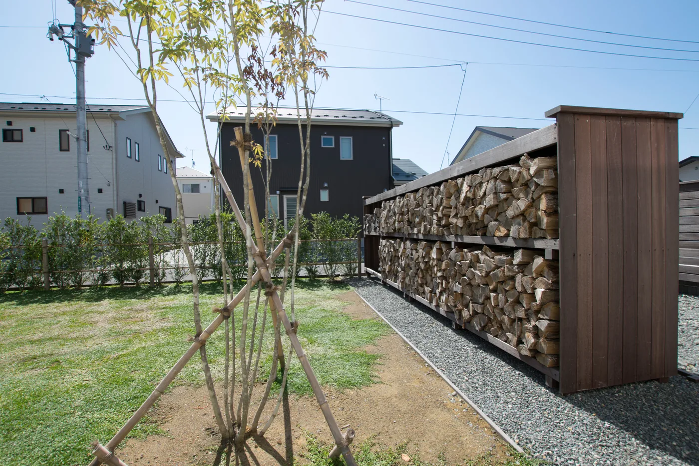 端部を板張りで整えたウリン薪棚と植栽