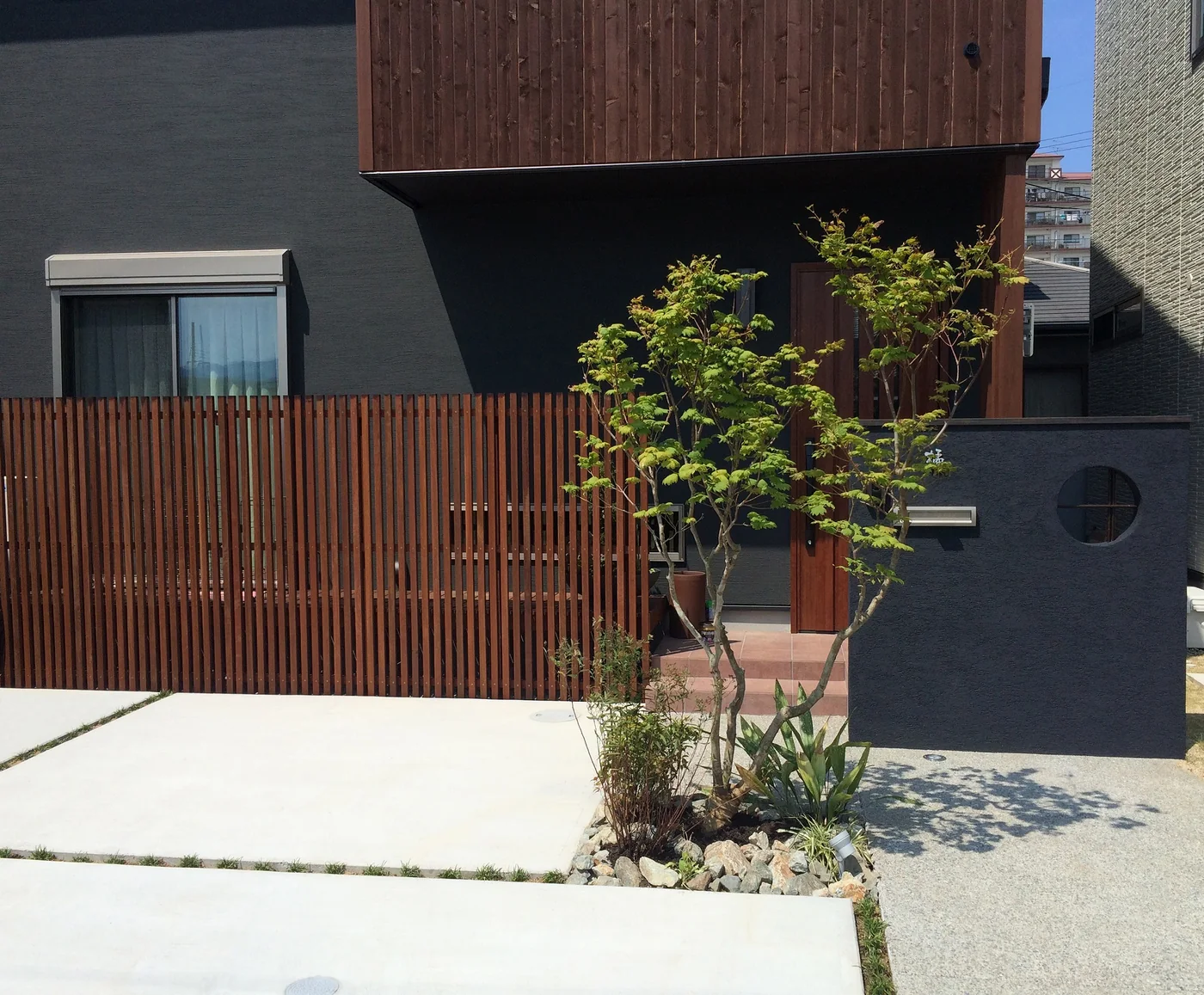 黒い外壁の住宅に合わせたウリン縦格子フェンスと玄関まわりの施工事例全景