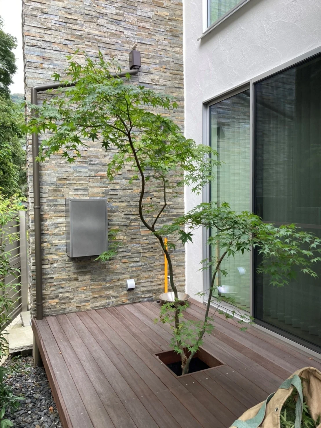 樹木を床面に取り込んだ建物脇のウリンテラス