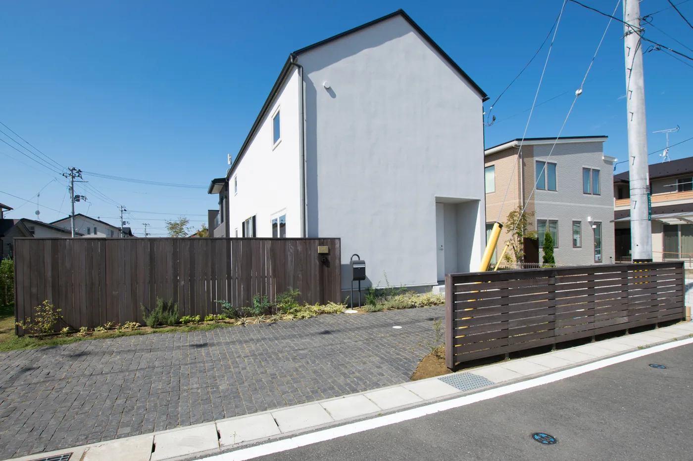 道路沿いに伸びるウリン横板フェンスと住宅外観