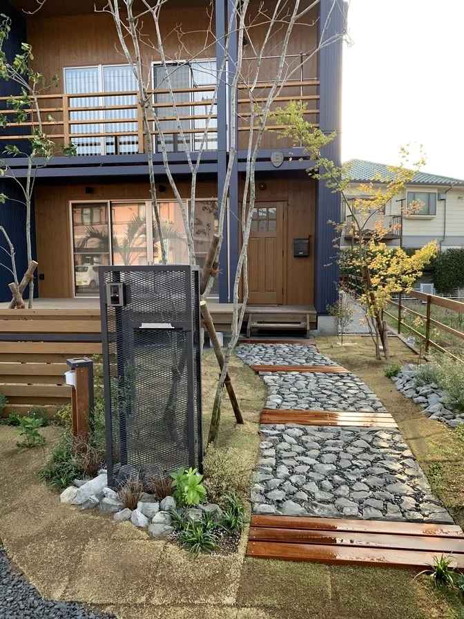 門まわりから玄関へ続く石敷きアプローチとウリン材の外構事例