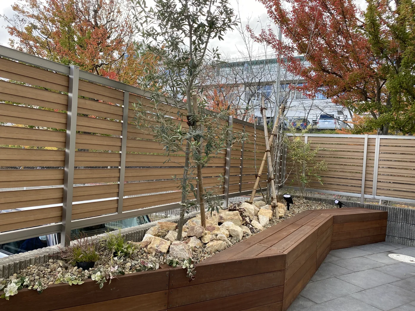 石と植栽を囲む折れ線状のウリン花壇兼ベンチ全景