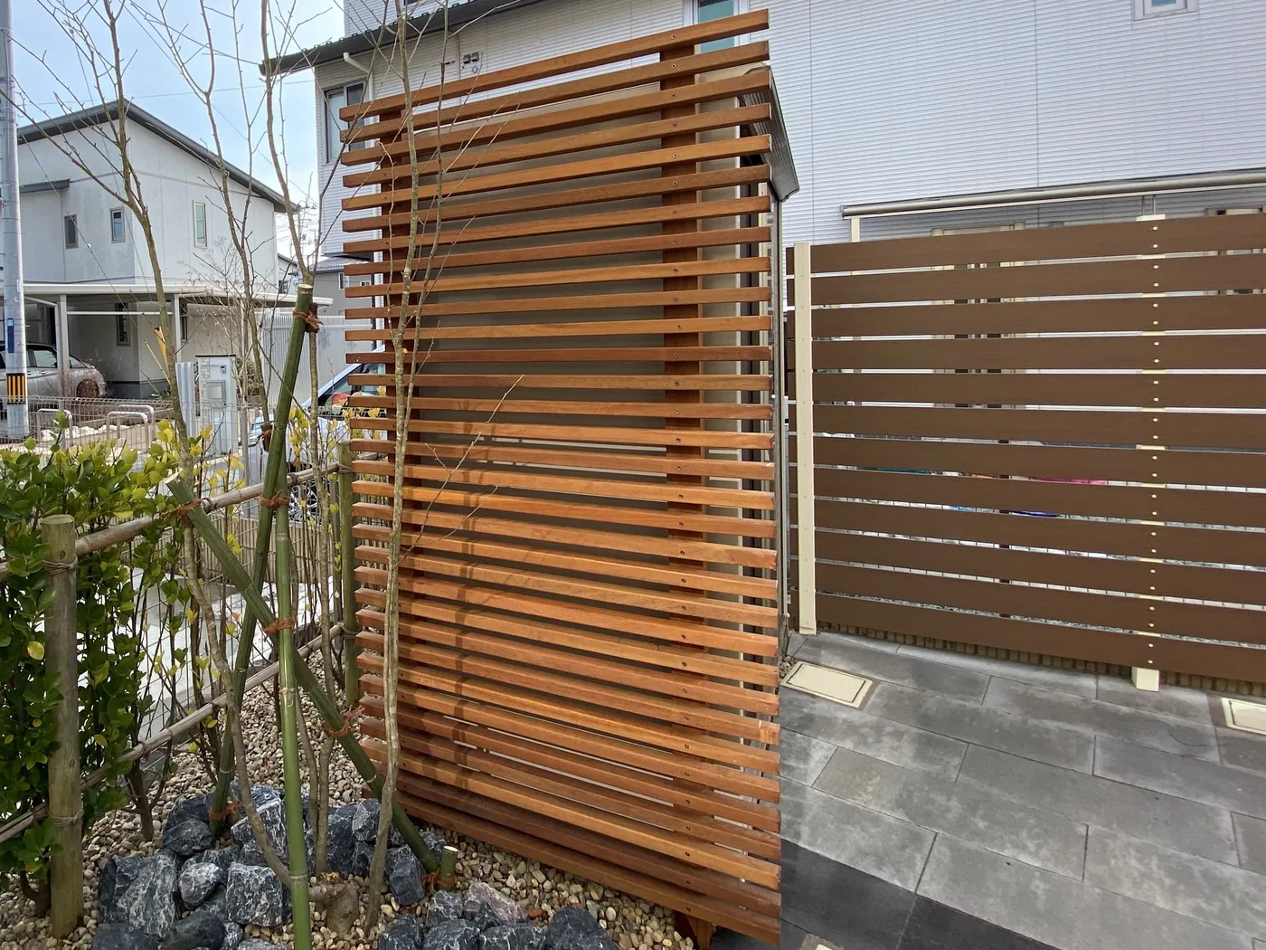 物置の前で中央がふくらむウリン立体ルーバーの全景