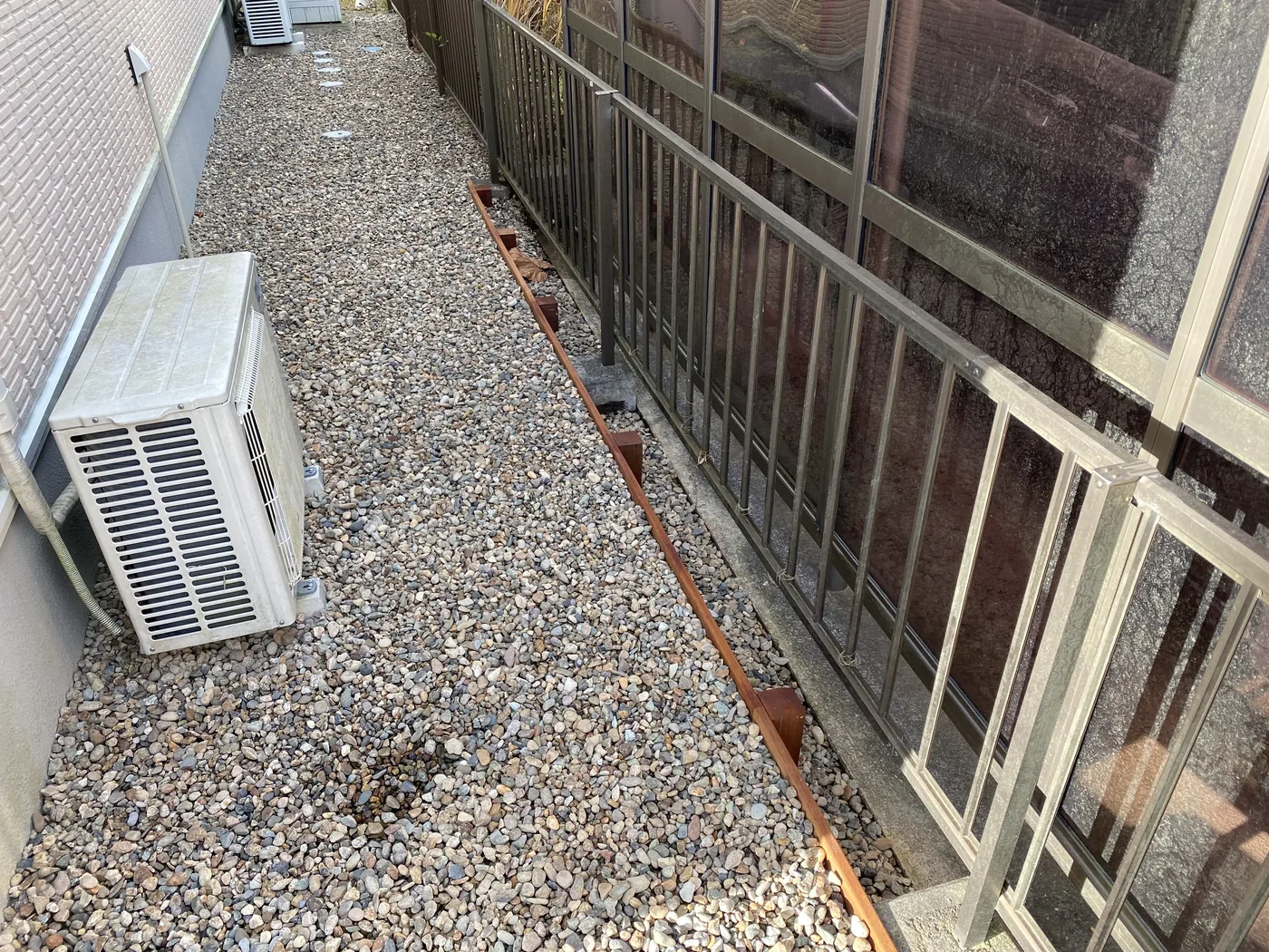 砂利敷きの外周部へ連続する低いウリン見切り