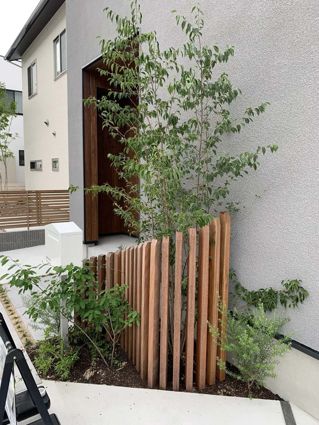 高さを変えた縦材と若木の幹が重なる側面