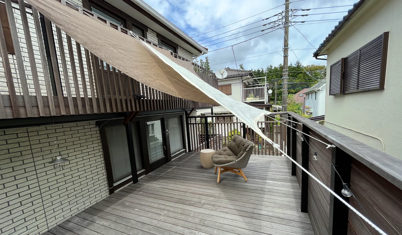 住宅の窓辺からデッキへ延びるシェード