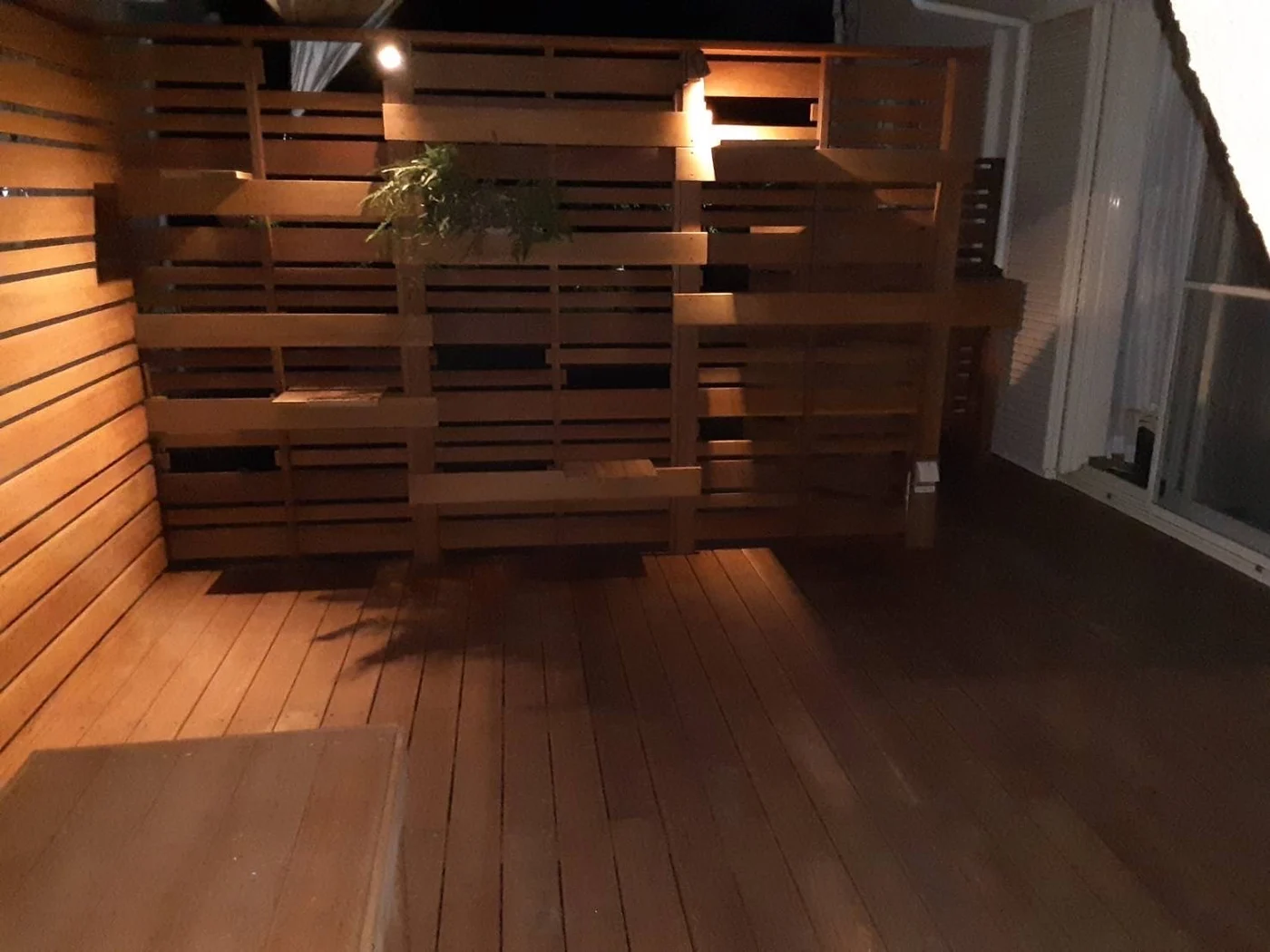横板の重なりに照明の影が映る夜の内観です