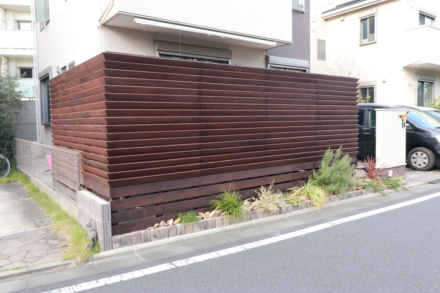 住宅の前を包む木製フェンスの全景