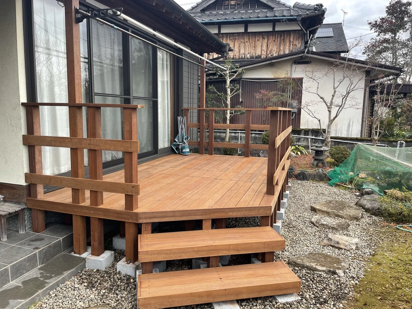 窓前のデッキから庭へ降りる階段を見た写真です