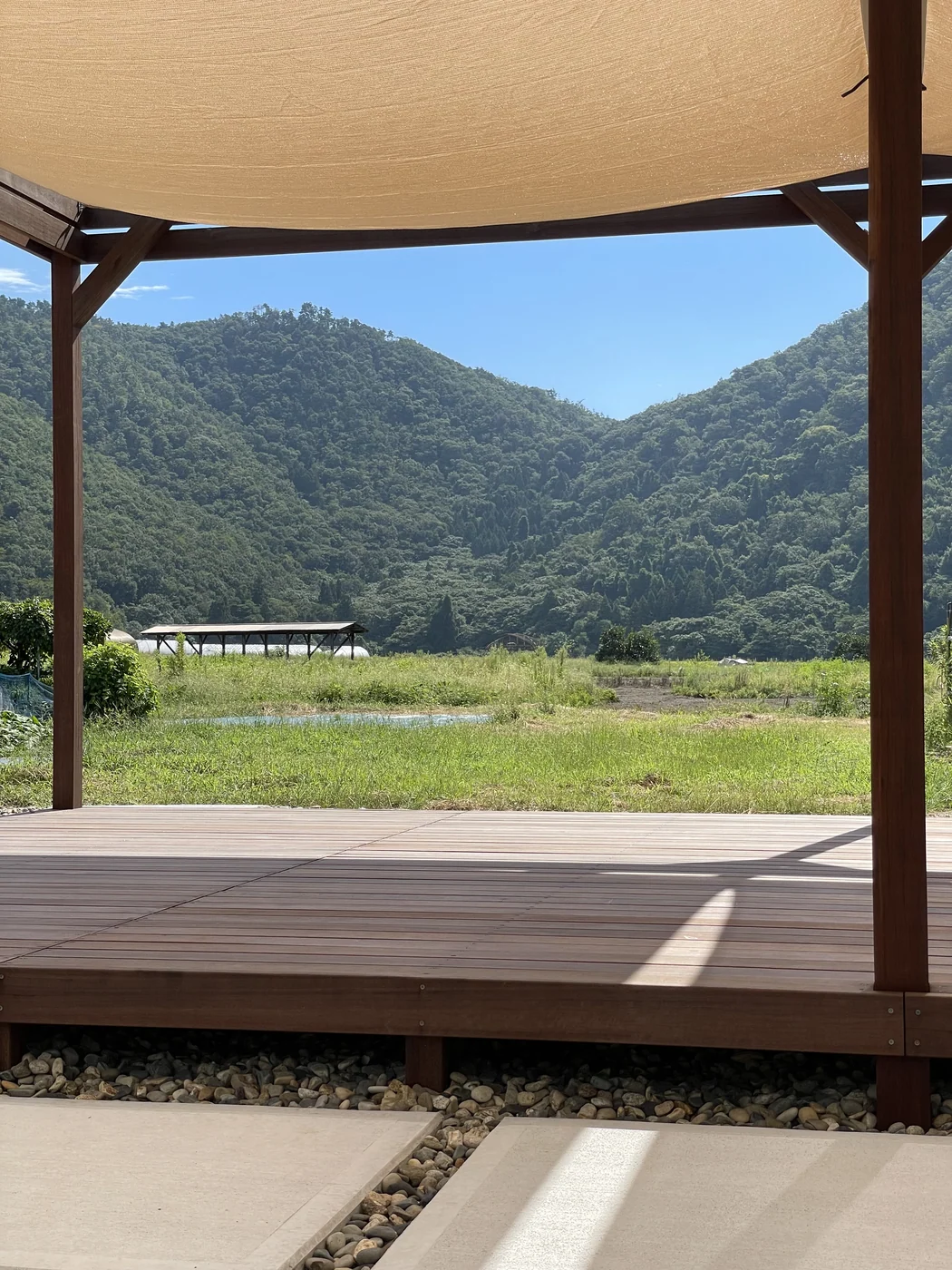 パーゴラの柱の間に広がる山並みと木の床