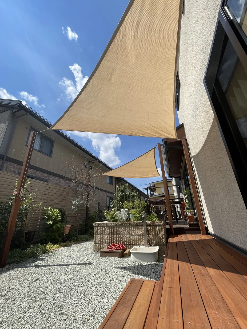 シェードの下を住宅沿いに延びる縁側状の床